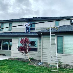 man on roof installing gutters